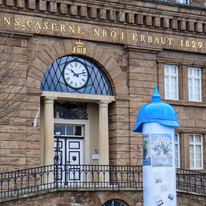 Die fertig beklebte Litfaßsäule mit Pickelhauben-Helm (vergrößerte Bildansicht wird geöffnet)
